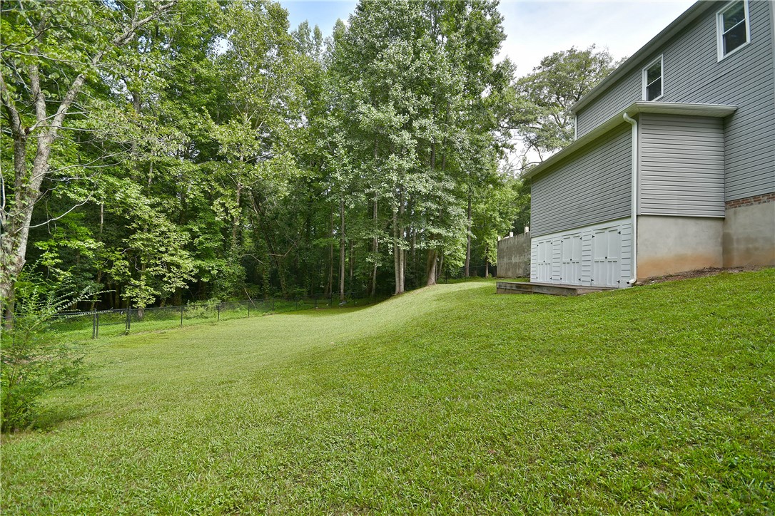 197 Deer Creek Road Easley, SC 29640 - Photo 48 of 50 A spacious backyard with mature trees provides ample green space for outdoor activities.