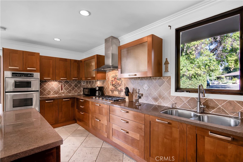 3701 Royal Meadow Road Sherman Oaks, CA 91403 - Photo 18 of 43 a kitchen with stainless steel appliances wooden cabinets a sink and a stove