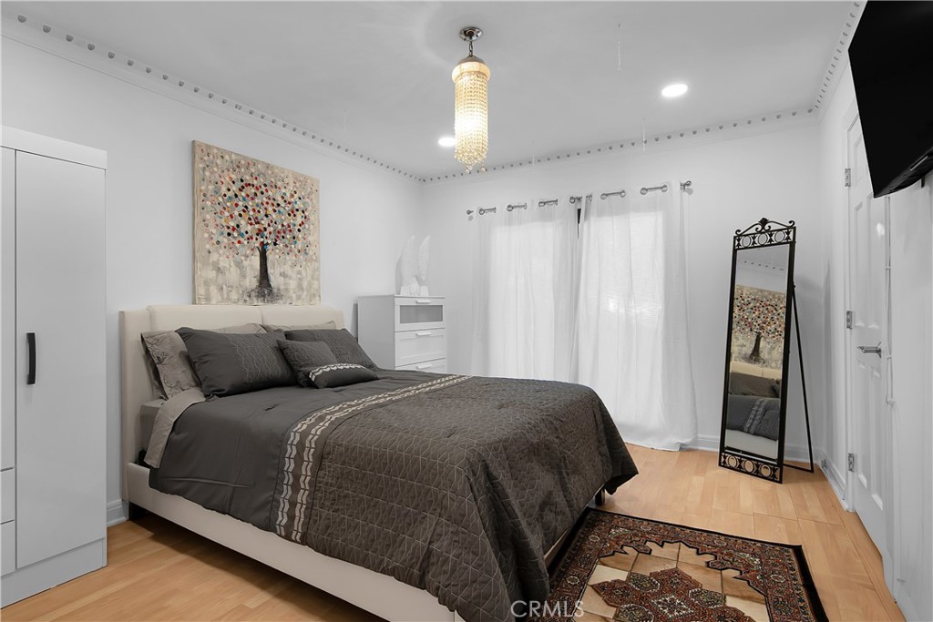 3701 Royal Meadow Road Sherman Oaks, CA 91403 - Photo 33 of 43 a bedroom with a large bed and a chandelier