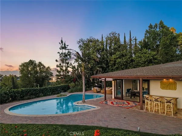 a swimming pool with lots of tress in front of it