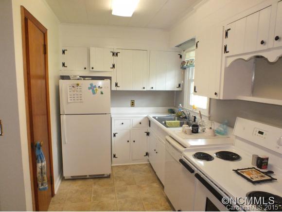 1105 Moody Farm Road Maggie Valley, NC 28751 - Photo 3 of 22 a kitchen with a refrigerator a sink and cabinets