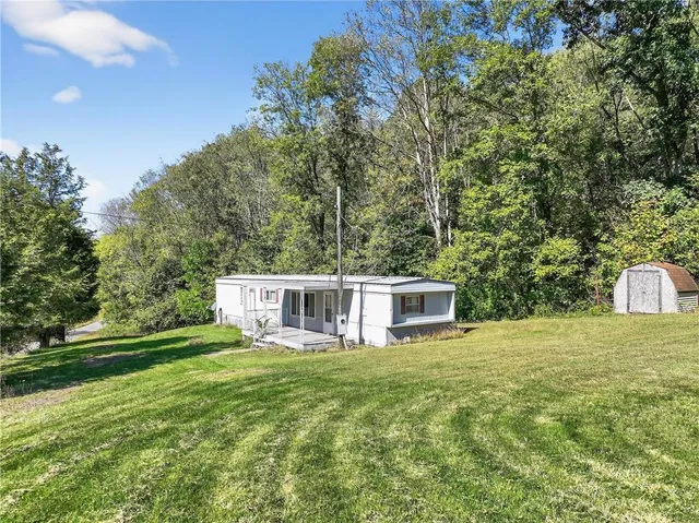 a view of a house with a yard and sitting area