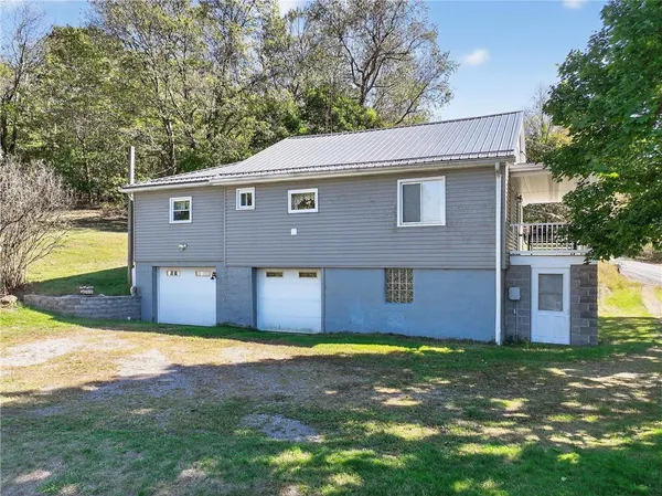 a front view of house with yard and trees in the background