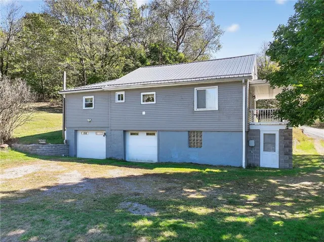 a front view of house with yard and trees in the background
