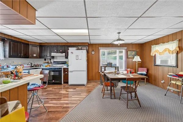 a kitchen with stainless steel appliances kitchen island granite countertop a table chairs a sink dishwasher and cabinets