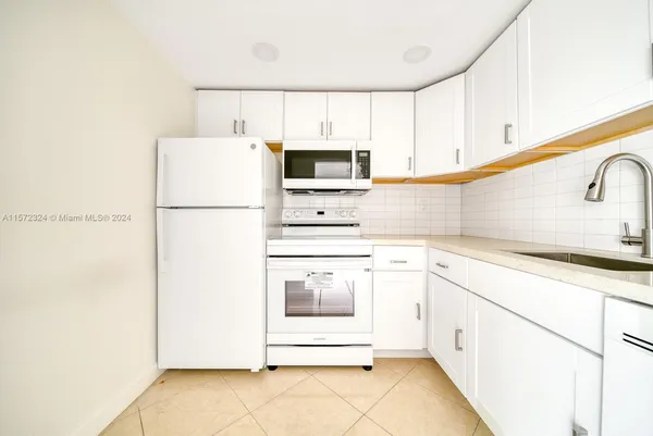 a kitchen with a white cabinets and white appliances