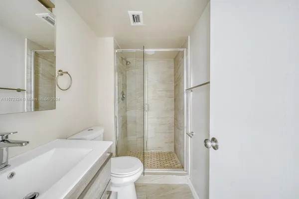 a bathroom with a sink toilet vanity and shower