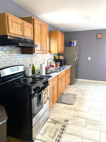 a kitchen with stainless steel appliances a stove sink and cabinets