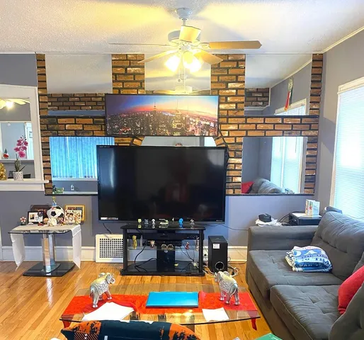 a living room with furniture a flat screen tv and next to a window