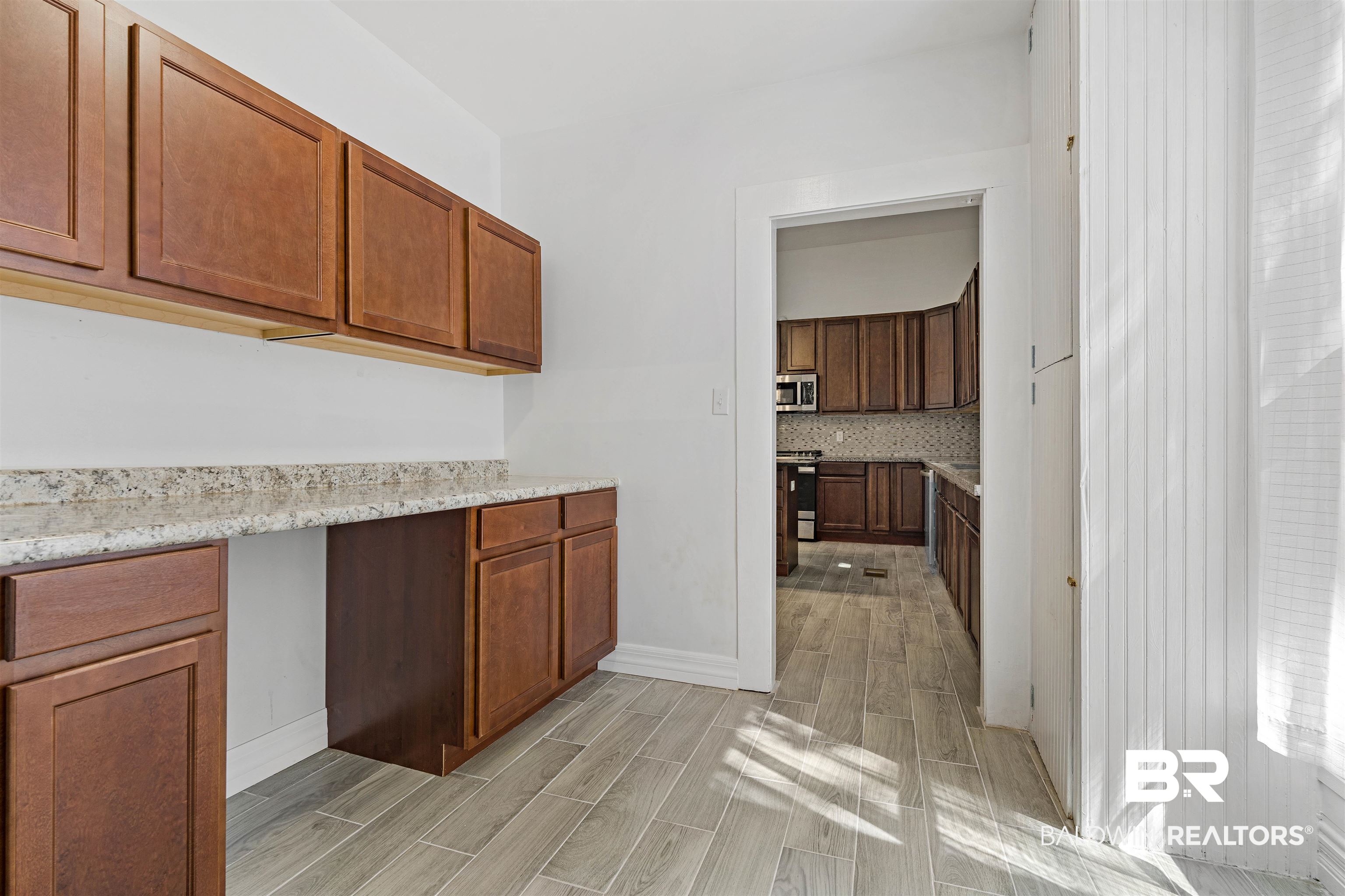 407 East 2nd Street Bay Minette, AL 36507 - Photo 11 of 40 Kitchen with brown cabinets, decorative backsplash, wood tiled floors, and stainless steel appliances