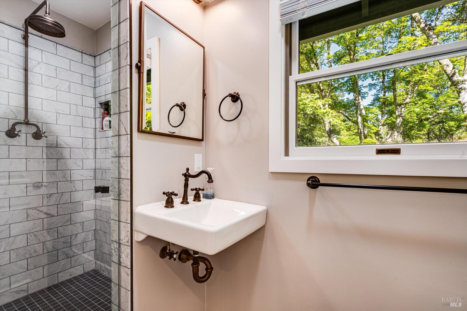 850 Conn Valley Road St. Helena, CA 94574 - Photo 15 of 79 a bathroom with a sink a mirror a window and a shower