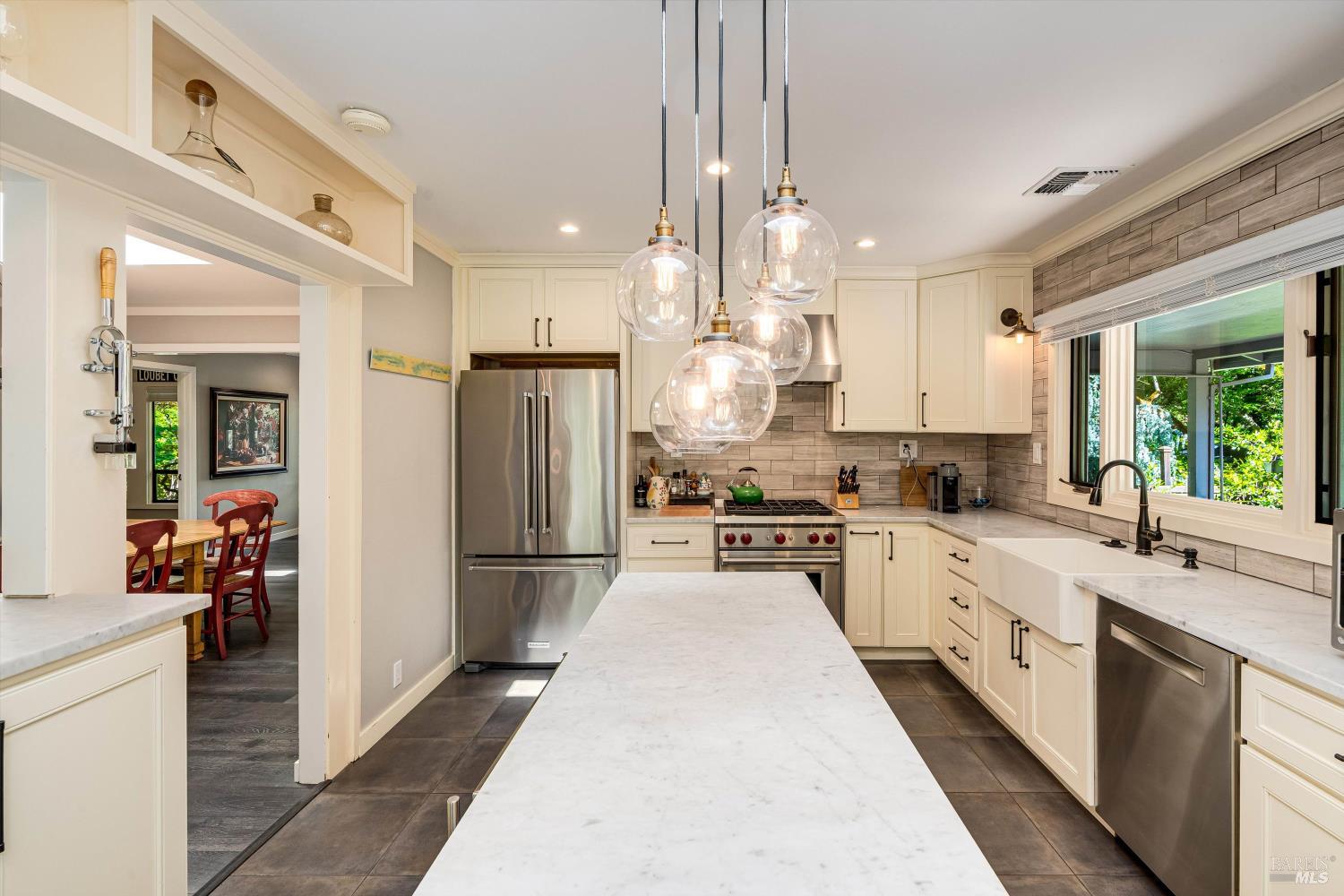 850 Conn Valley Road St. Helena, CA 94574 - Photo 34 of 79 a large kitchen with stainless steel appliances kitchen island granite countertop a refrigerator a sink dishwasher a stove and white cabinets with wooden floor