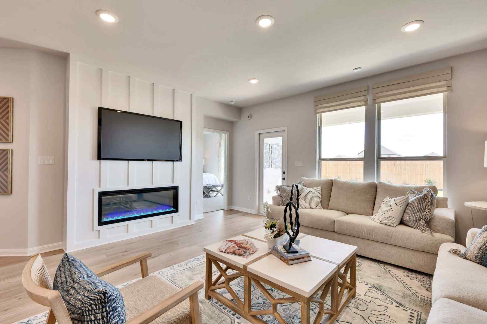 1205 Lavender Way Georgetown, TX 78628 - Photo 2 of 14 An inviting gathering space features an electric fireplace with a contemporary mantel and recessed lighting, creating a comfortable ambiance.
