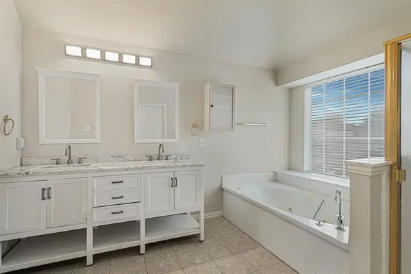 a bathroom with a granite countertop sink mirror and a bathtub