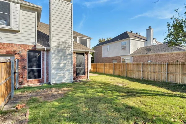 a view of a house with a yard and wooden fence