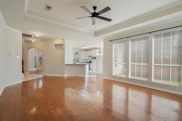 a view of an empty room with a window and wooden floor