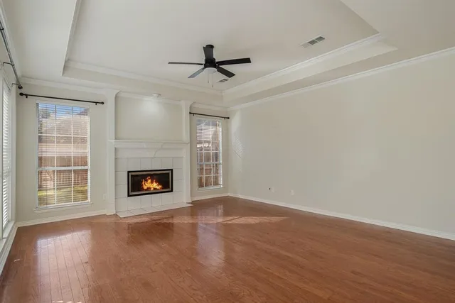 an empty room with windows fireplace and a sink