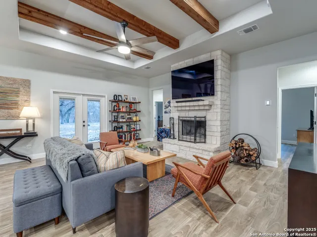 a living room with furniture a flat screen tv and a fireplace