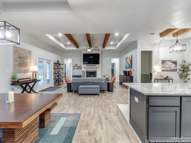 a living room with stainless steel appliances kitchen island granite countertop furniture a flat screen tv and a faucet