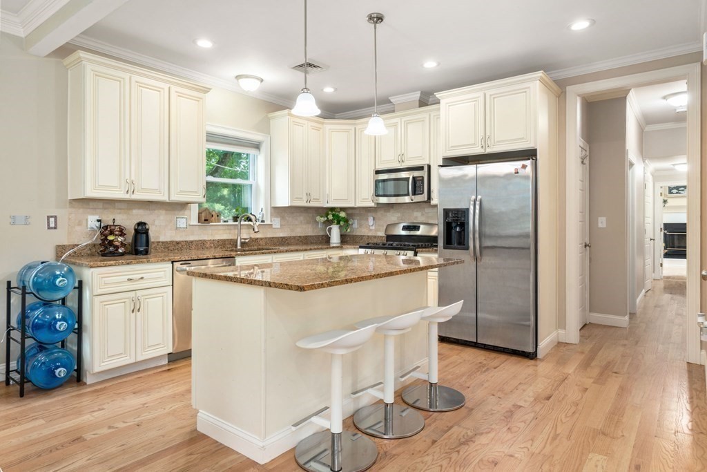 263 Marrett Road Lexington, MA 02421 - Photo 8 of 26 a kitchen with stainless steel appliances granite countertop a refrigerator a sink dishwasher a stove and white cabinets with wooden floor