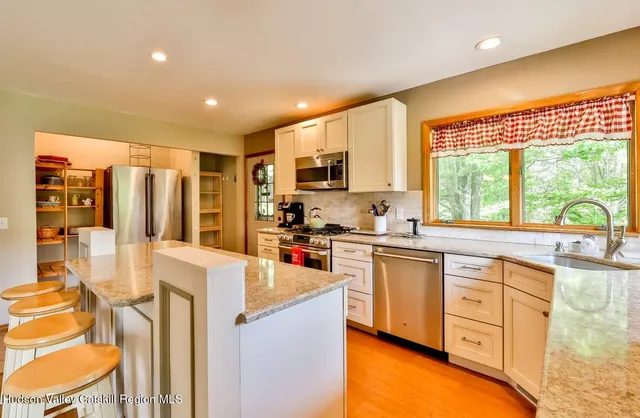 a kitchen with stainless steel appliances granite countertop a stove a sink and a refrigerator
