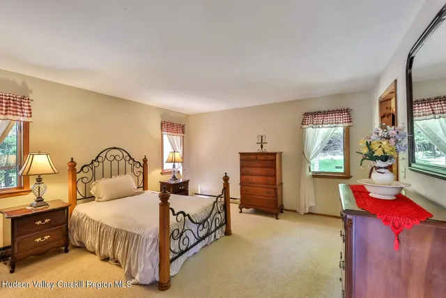 a bedroom with a bed and dresser with mirror