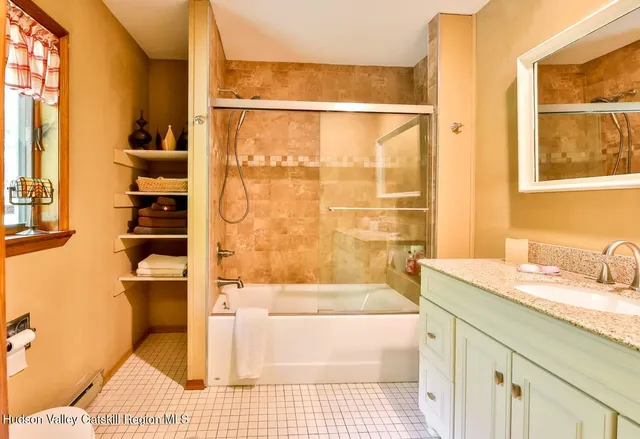a bathroom with a granite countertop sink and a bathtub