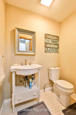 a bathroom with a sink a toilet and mirror