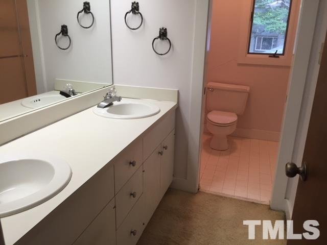 8908 Woodvine Court Raleigh, NC 27613 - Photo 8 of 8 a bathroom with a sink and a mirror