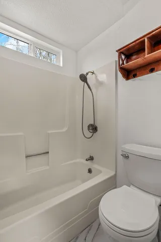 a bathroom with a granite countertop sink toilet a mirror and shower