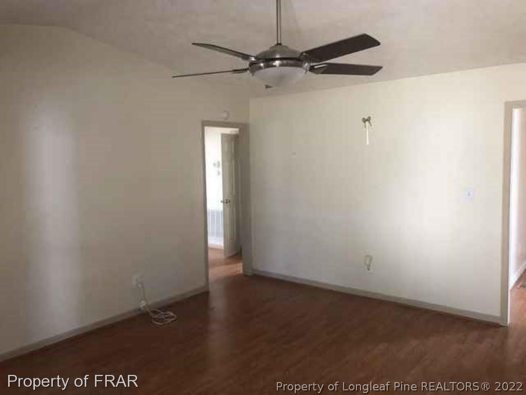 6516 Applewhite Road Fayetteville, NC 28304 - Photo 6 of 12 an empty room with a ceiling fan and wooden floor