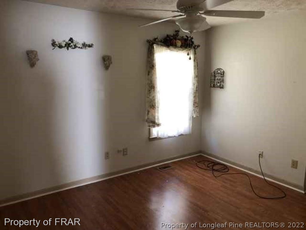 6516 Applewhite Road Fayetteville, NC 28304 - Photo 10 of 12 an empty room with a window and wooden floor