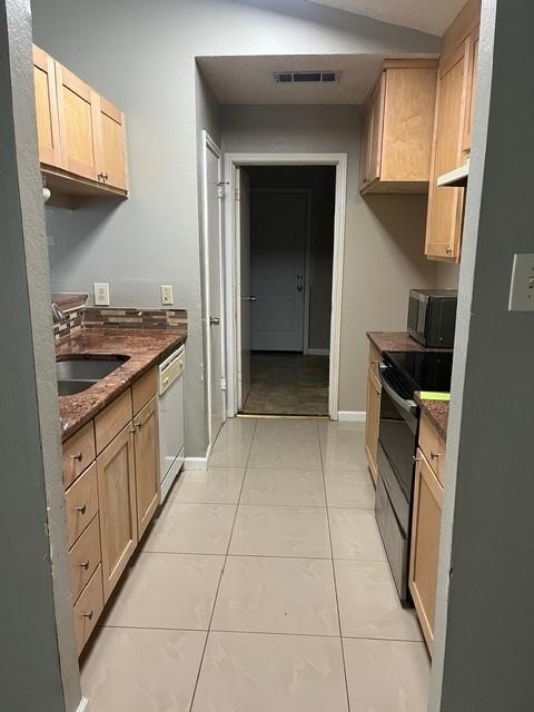 339 Fantail Loop, Unit B Austin, TX 78734 - Photo 7 of 13 a kitchen with a stove top oven cabinets and a refrigerator