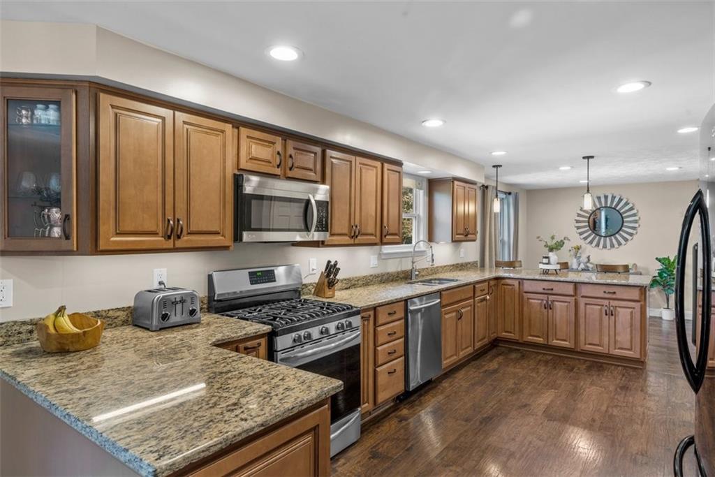 229 Lakeside Drive McKees Rocks, PA 15136 - Photo 12 of 35 a kitchen with stainless steel appliances granite countertop wooden cabinets a stove top oven a sink and dishwasher