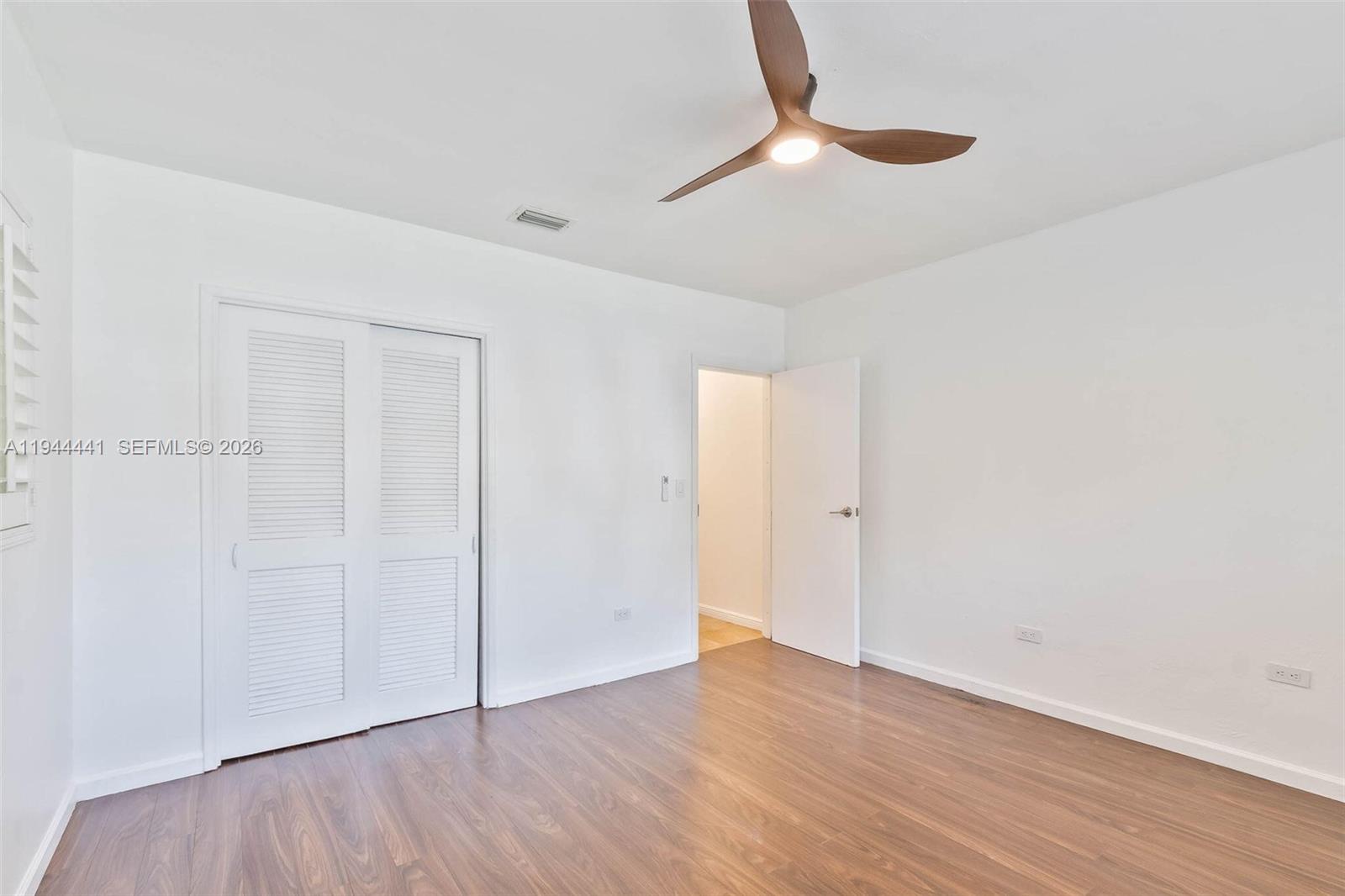 680 Northeast 57th Street Miami, FL 33137 - Photo 11 of 42 a view of an empty room with wooden floor