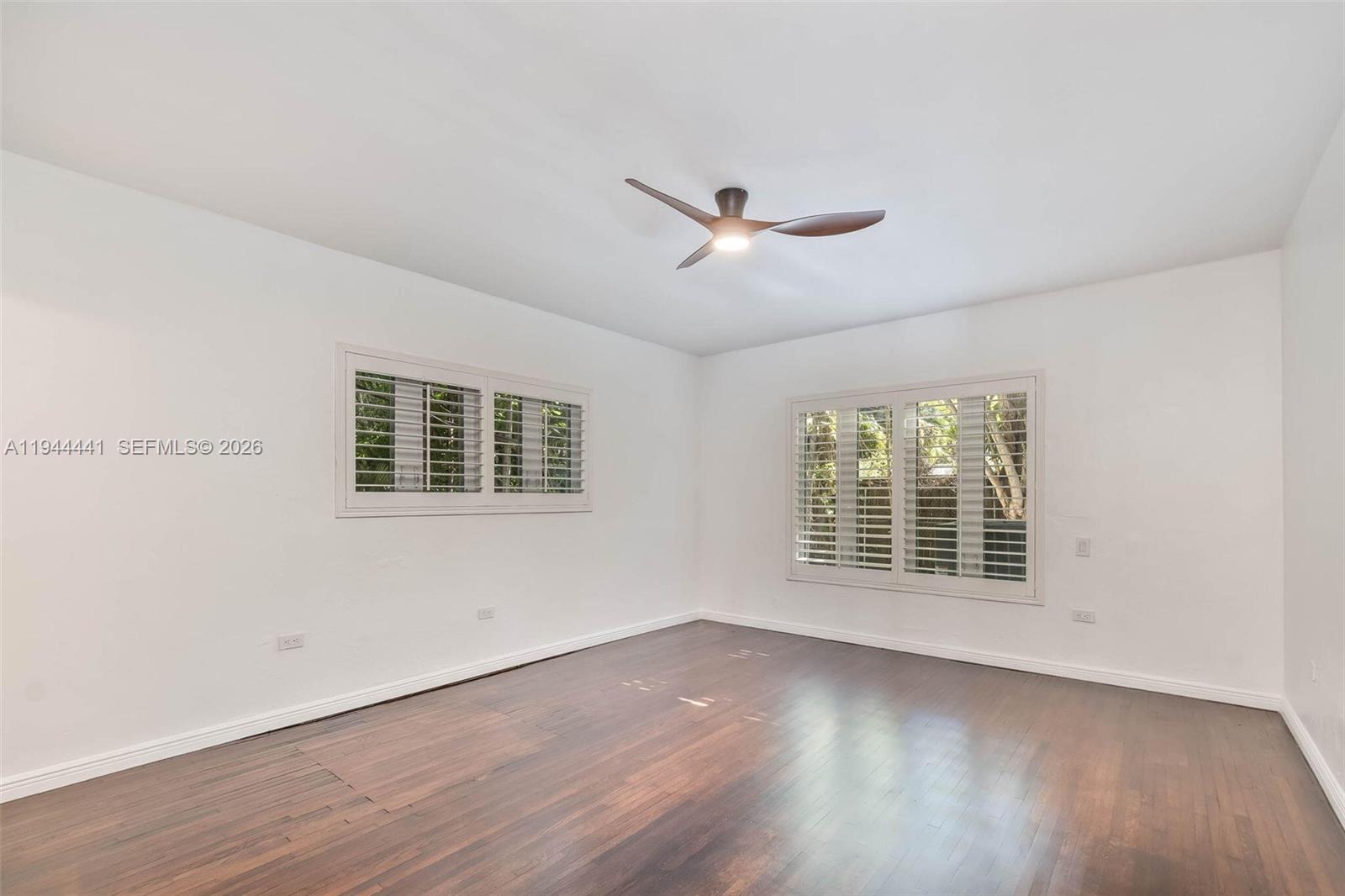 680 Northeast 57th Street Miami, FL 33137 - Photo 13 of 42 a view of an empty room with wooden floor and a window
