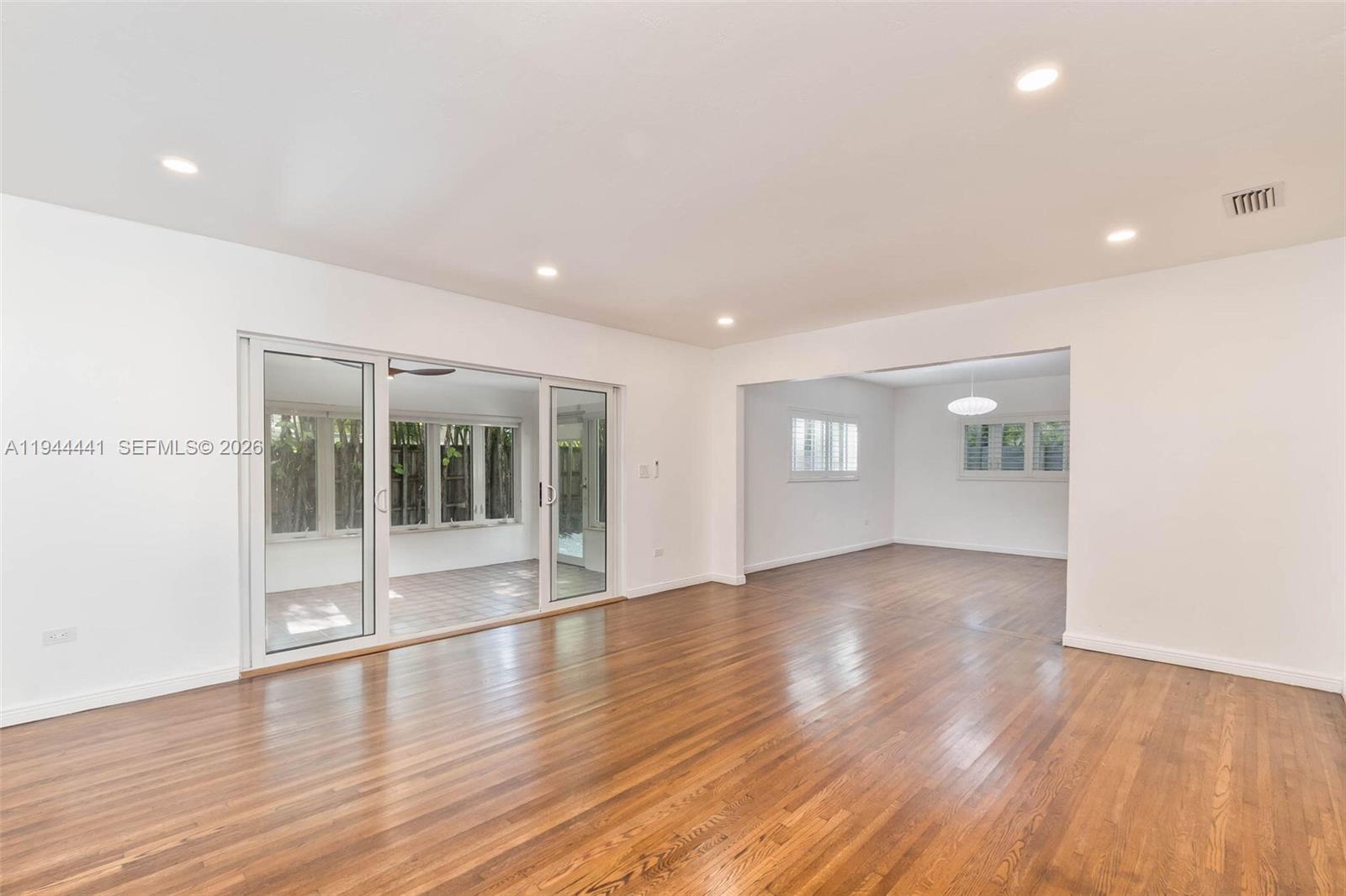 680 Northeast 57th Street Miami, FL 33137 - Photo 17 of 42 an empty room with wooden floor and windows