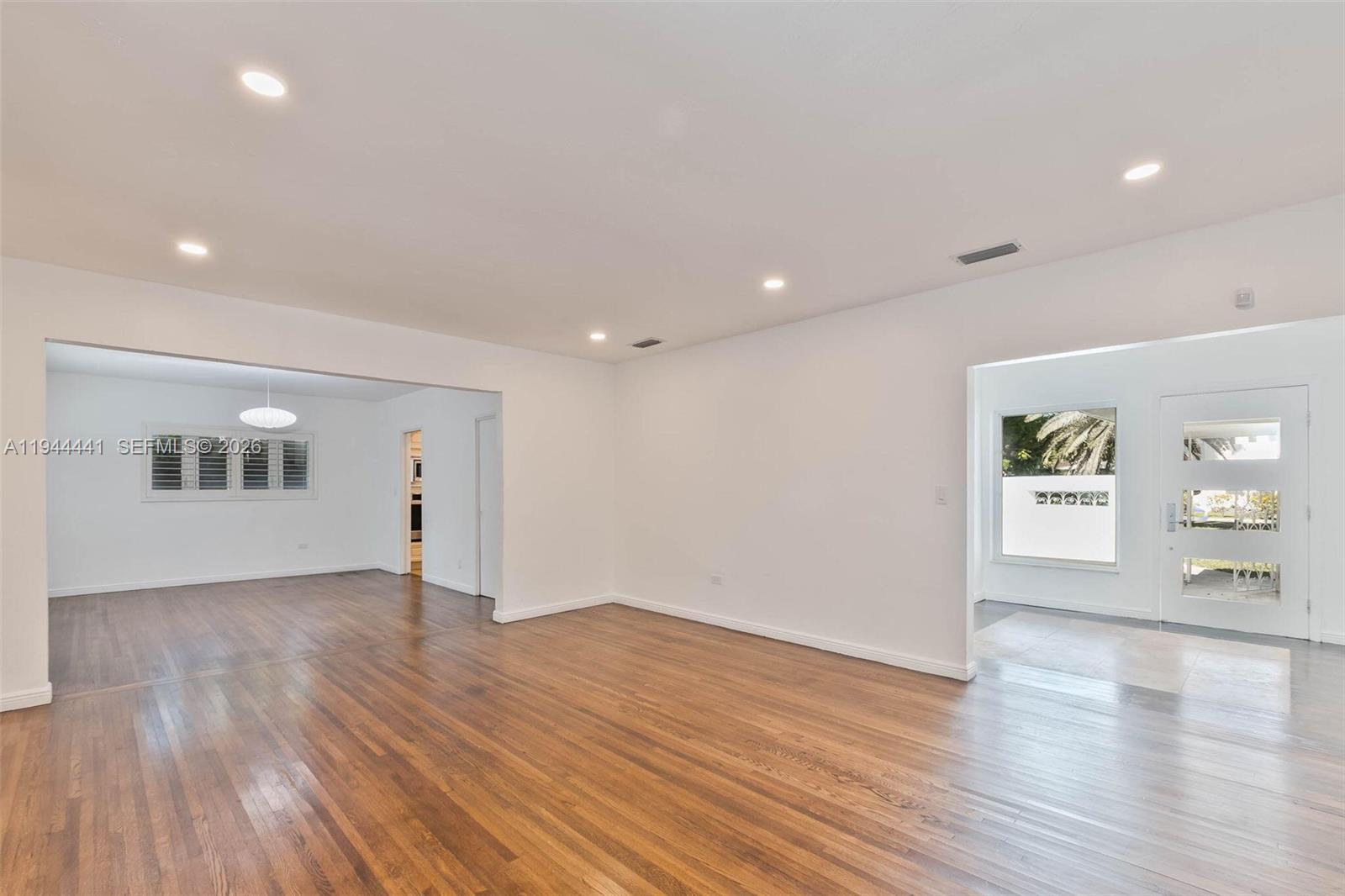 680 Northeast 57th Street Miami, FL 33137 - Photo 18 of 42 a view of an empty room with wooden floor and a window