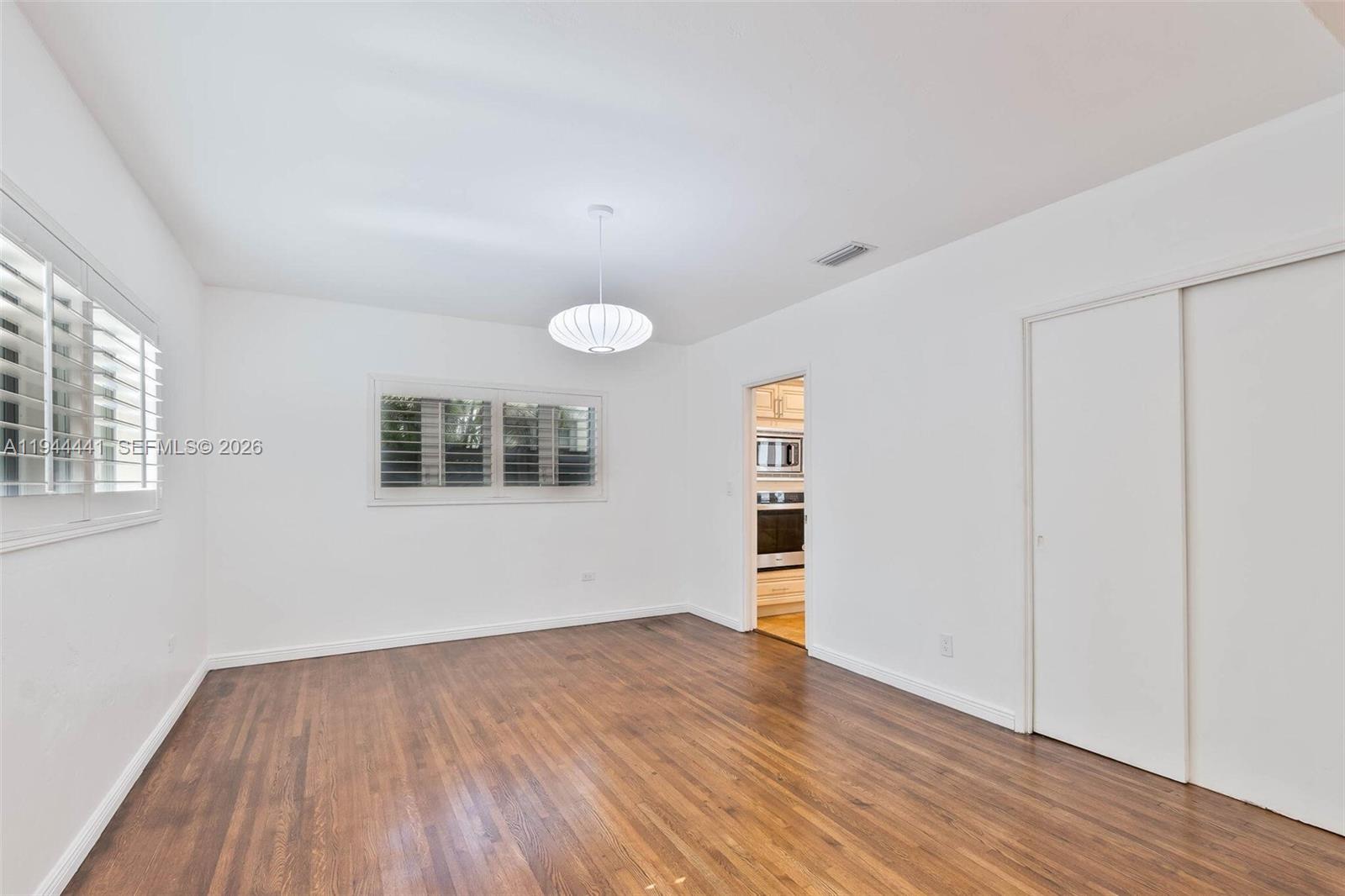 680 Northeast 57th Street Miami, FL 33137 - Photo 20 of 42 an empty room with wooden floor and window