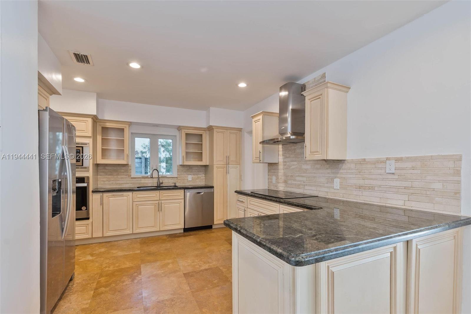 680 Northeast 57th Street Miami, FL 33137 - Photo 25 of 42 a kitchen with stainless steel appliances granite countertop a sink refrigerator and cabinets