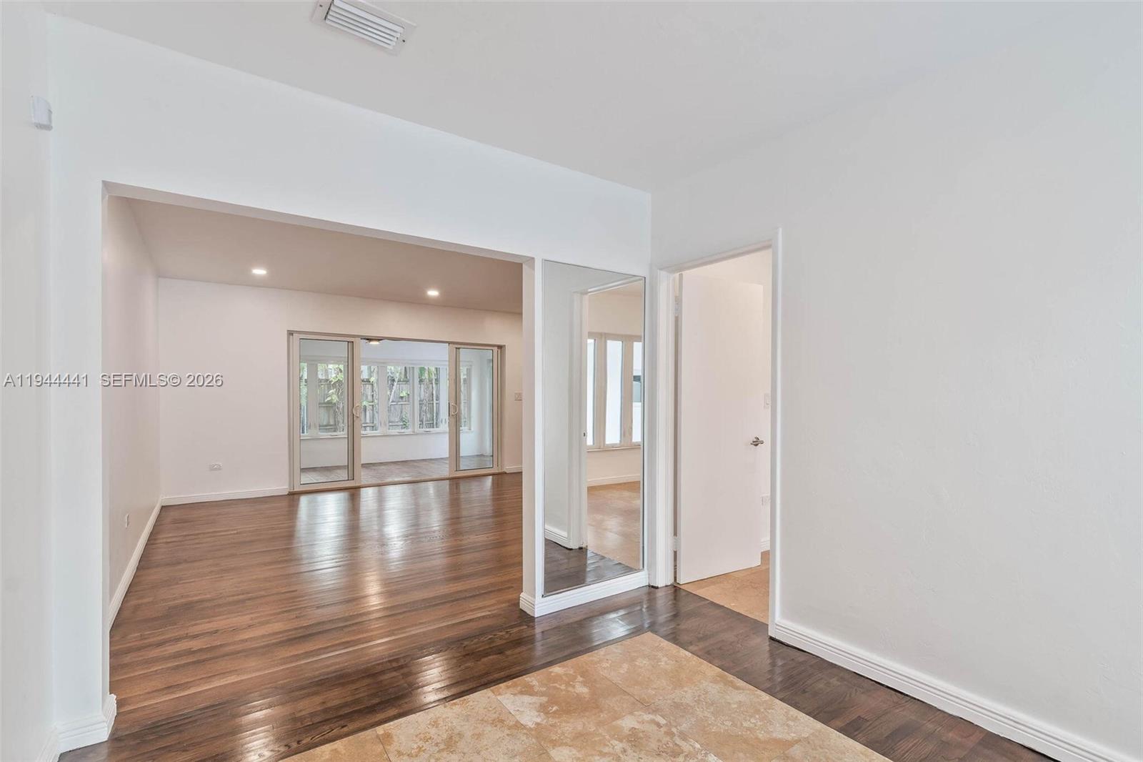 680 Northeast 57th Street Miami, FL 33137 - Photo 8 of 42 a view of an empty room with wooden floor and a window