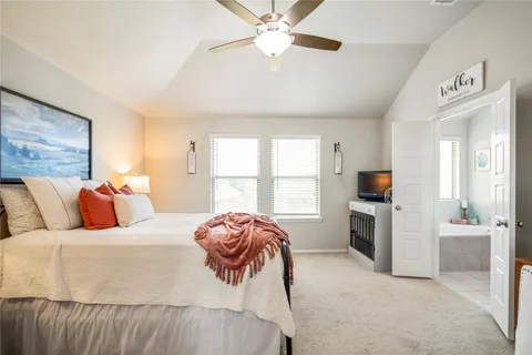 a bedroom with a bed dresser and a flat tv screen