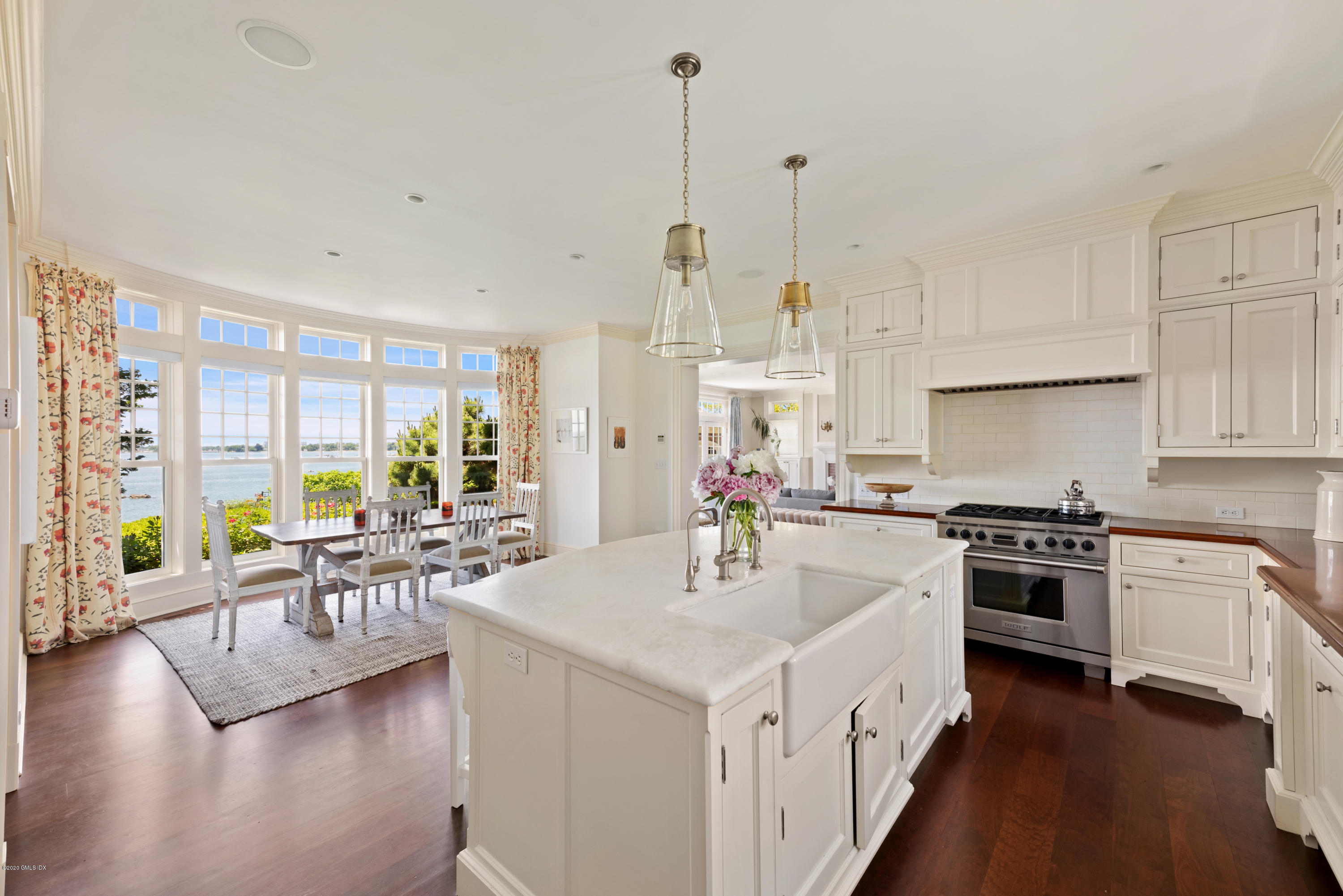 224 Long Neck Point Road Darien, CT 06820 - Photo 14 of 33 a kitchen with stove a sink and white cabinets with wooden floor