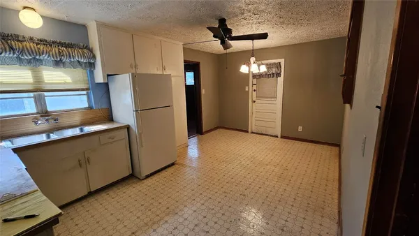 a view of kitchen with refrigerator and window