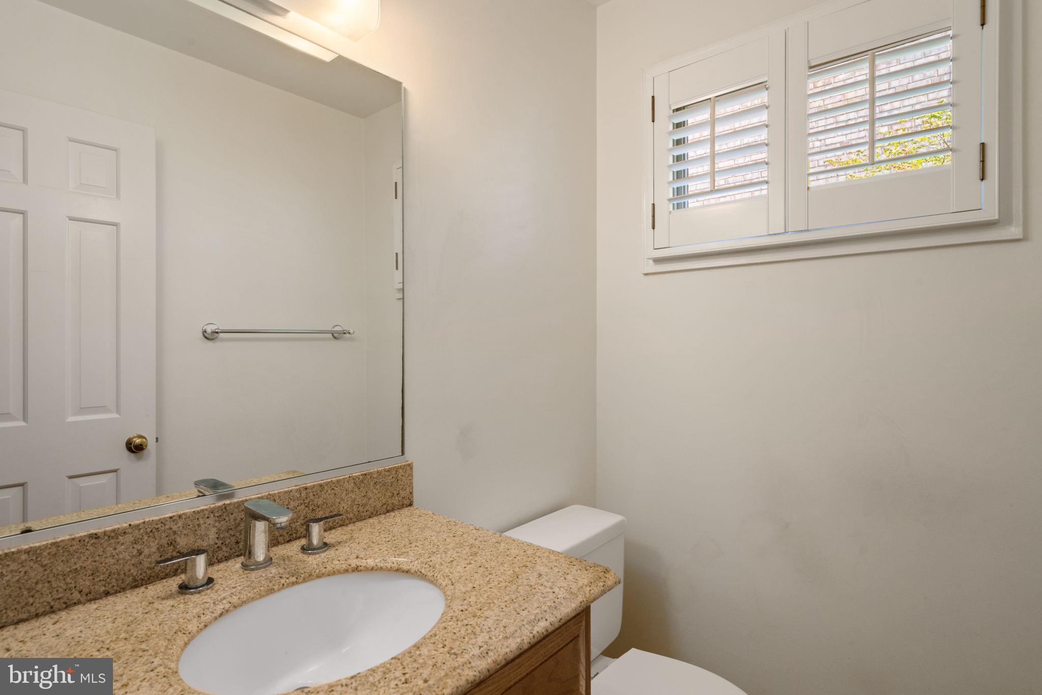 6716 Baron Road McLean, VA 22101 - Photo 22 of 41 a bathroom with a granite countertop sink toilet and mirror
