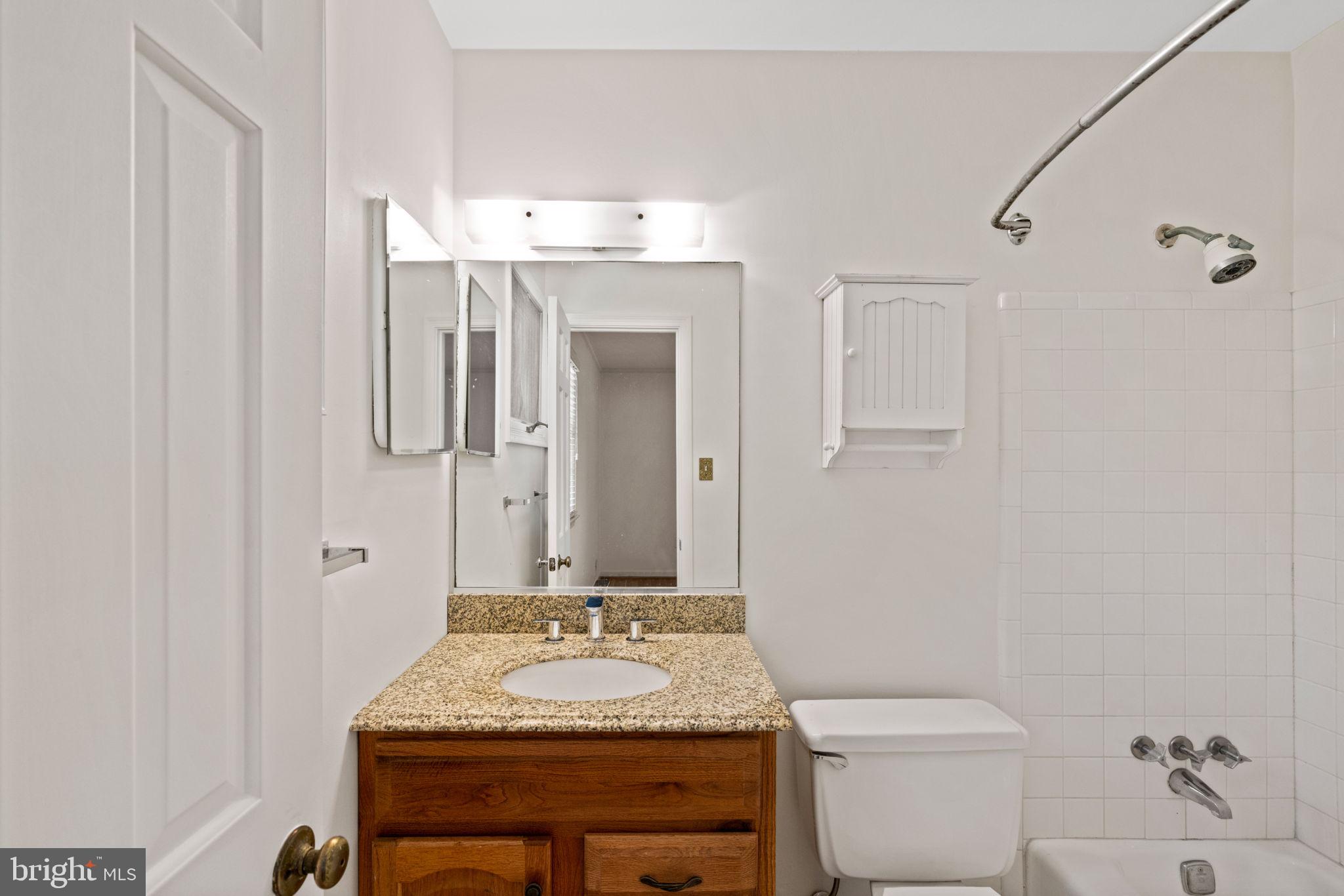 6716 Baron Road McLean, VA 22101 - Photo 31 of 41 a bathroom with a granite countertop sink a toilet and a mirror