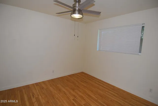 a view of empty room with wooden floor