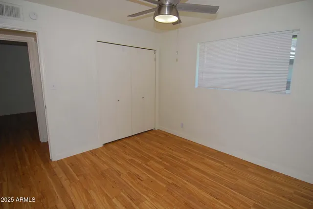 a view of empty room with wooden floor