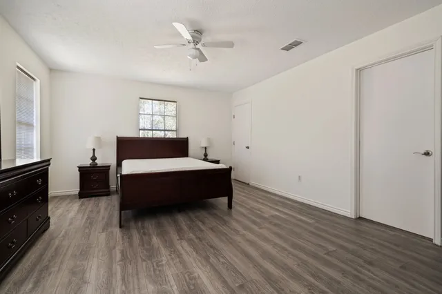 a spacious bedroom with a bed and a tv on table