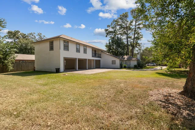 a view of an house with backyard and trees